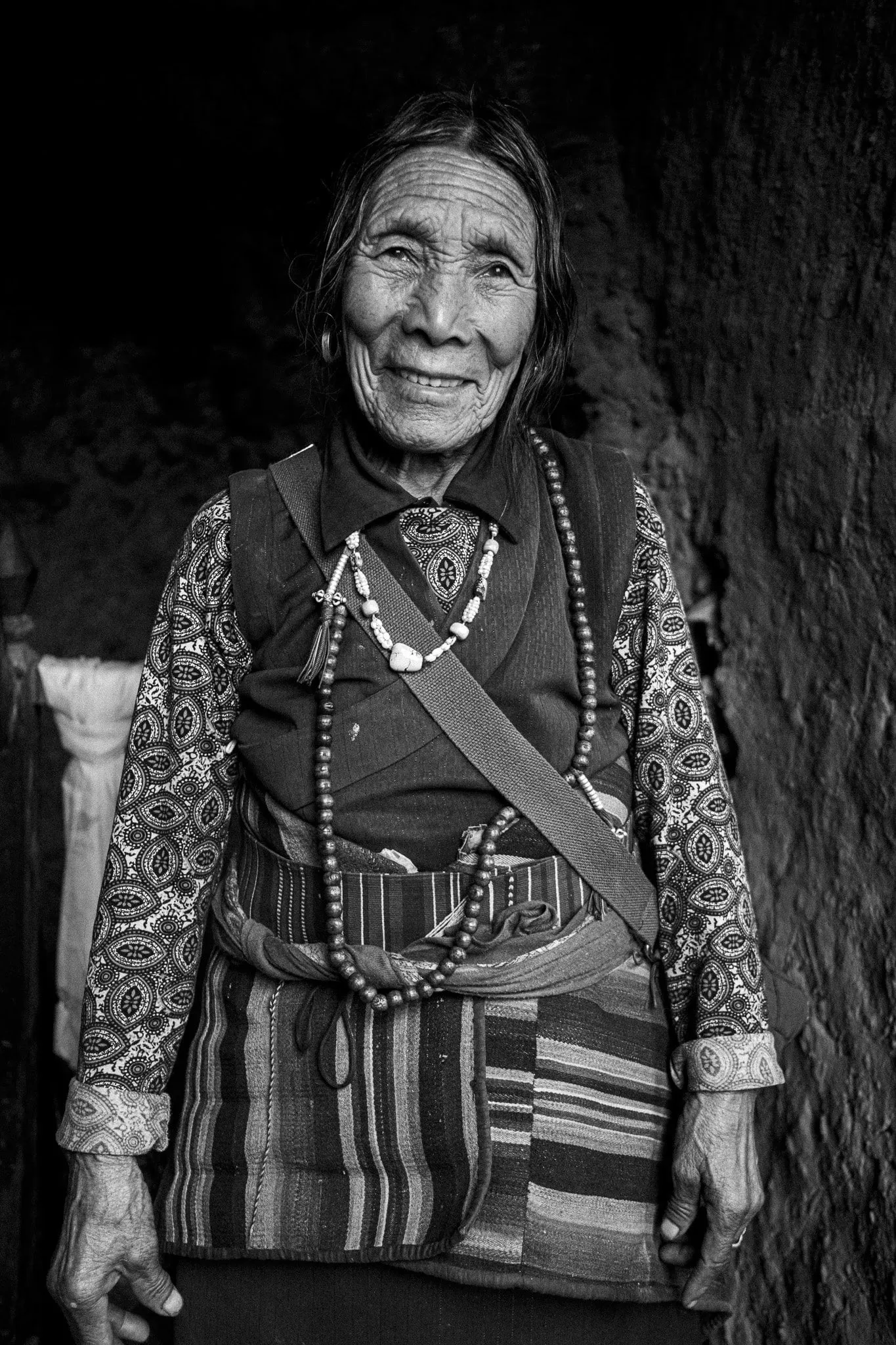 A black and white portrait photo of an elderly Nepali woman at Luri Gompa in Upper Mustang, Nepal