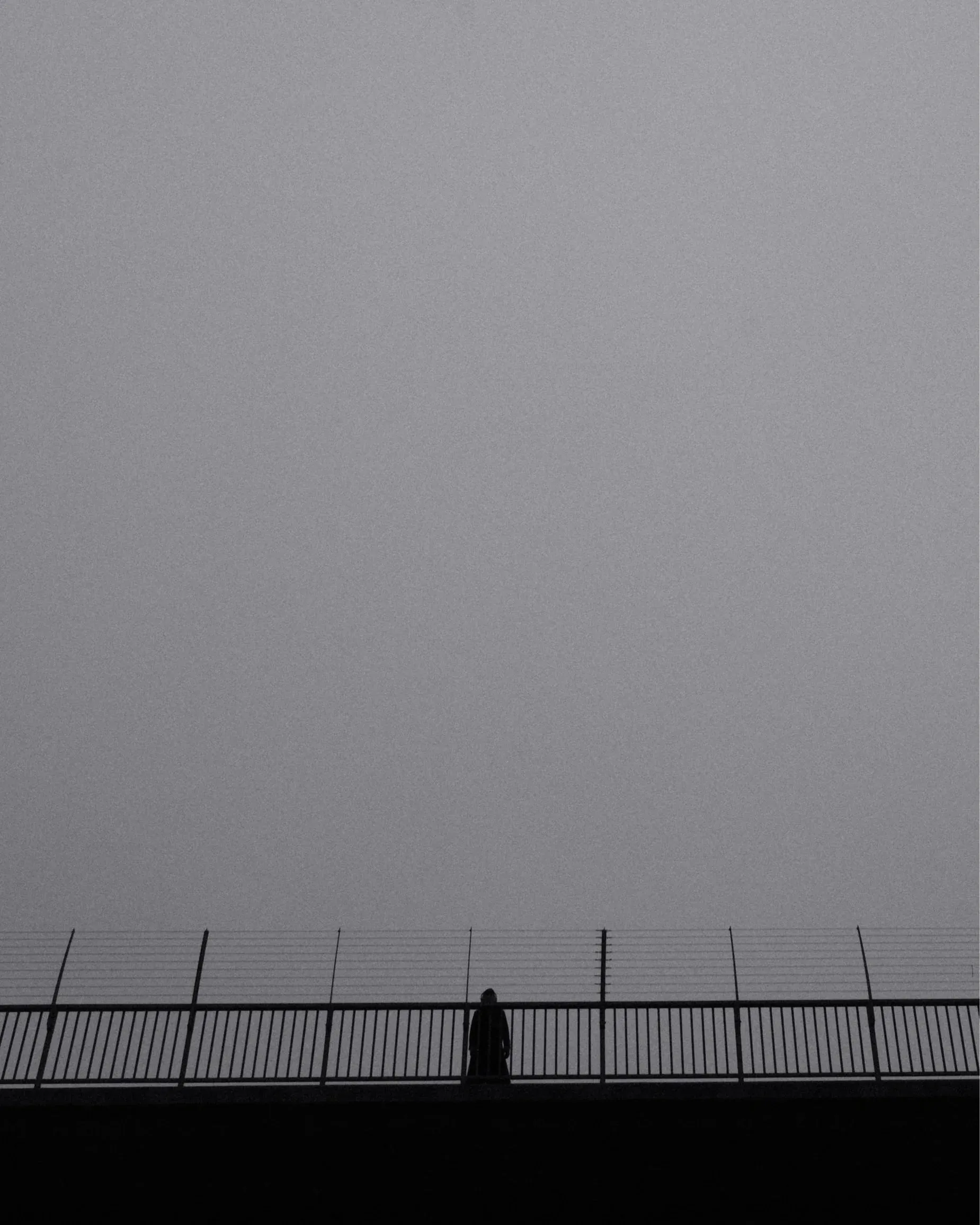 A woman looks out towards the winter sky from Västerbron bridge at Kungsholmen.