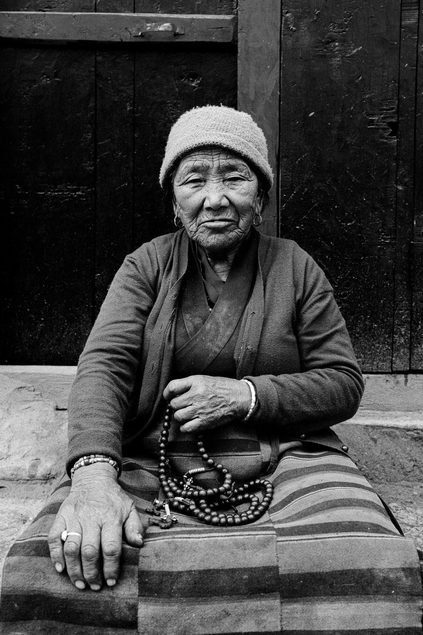 Black and white photo of an elderly woman in Lo Manthang, Upper Mustang, Nepal