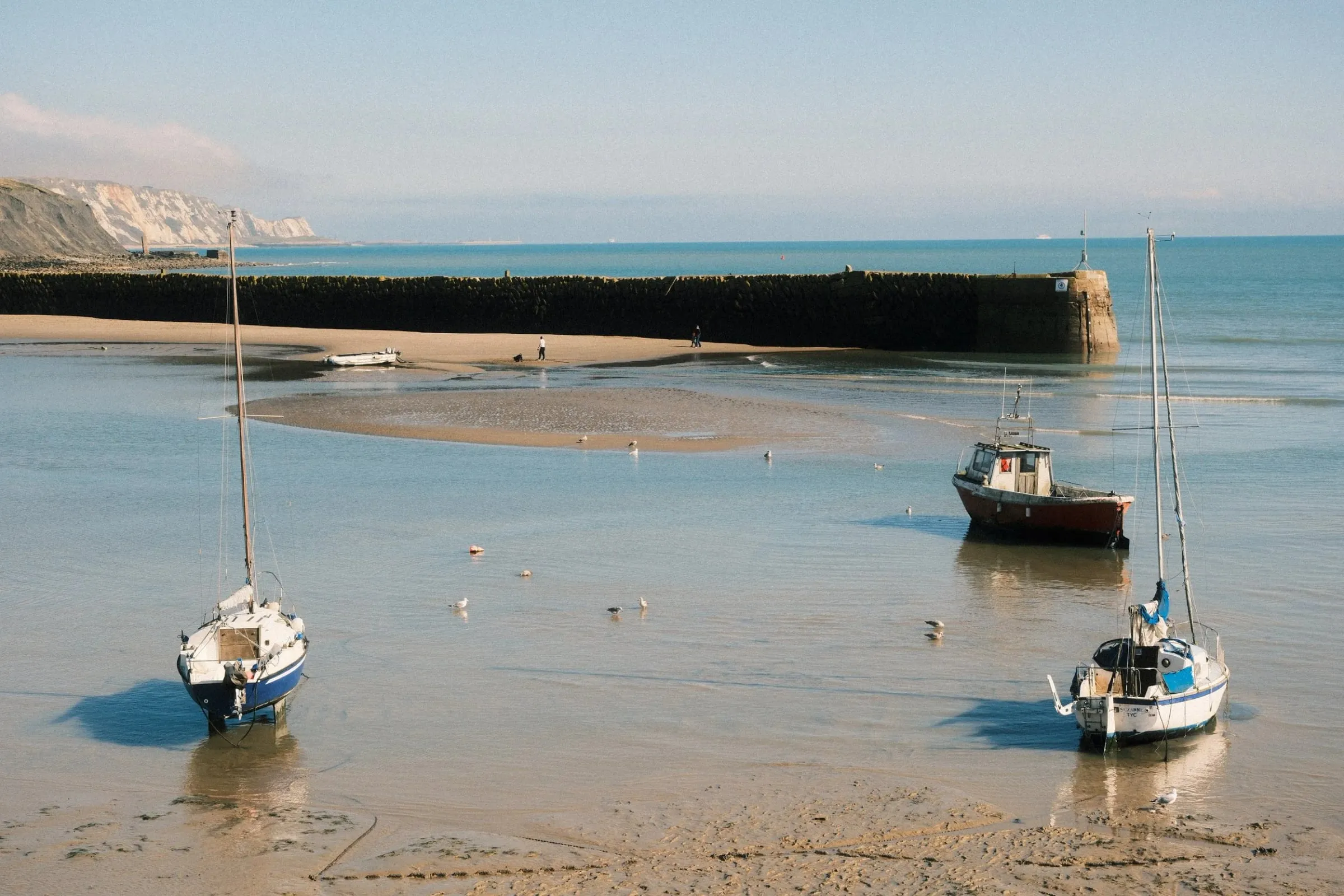Boats sitting on Folkestone Harbour floor at low tide