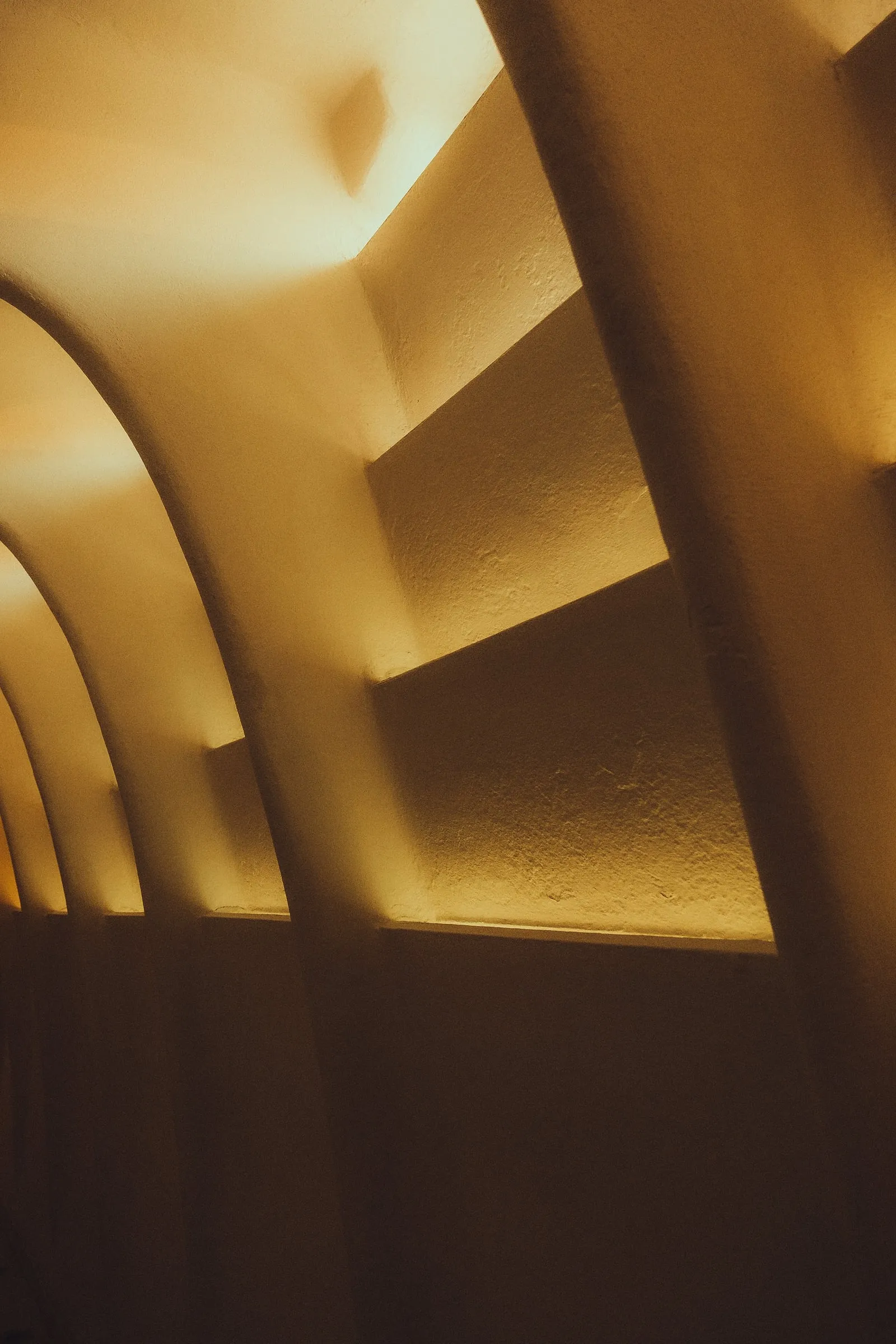 Curved plaster walls and ceiling glowing in warm light inside Casa Batlló