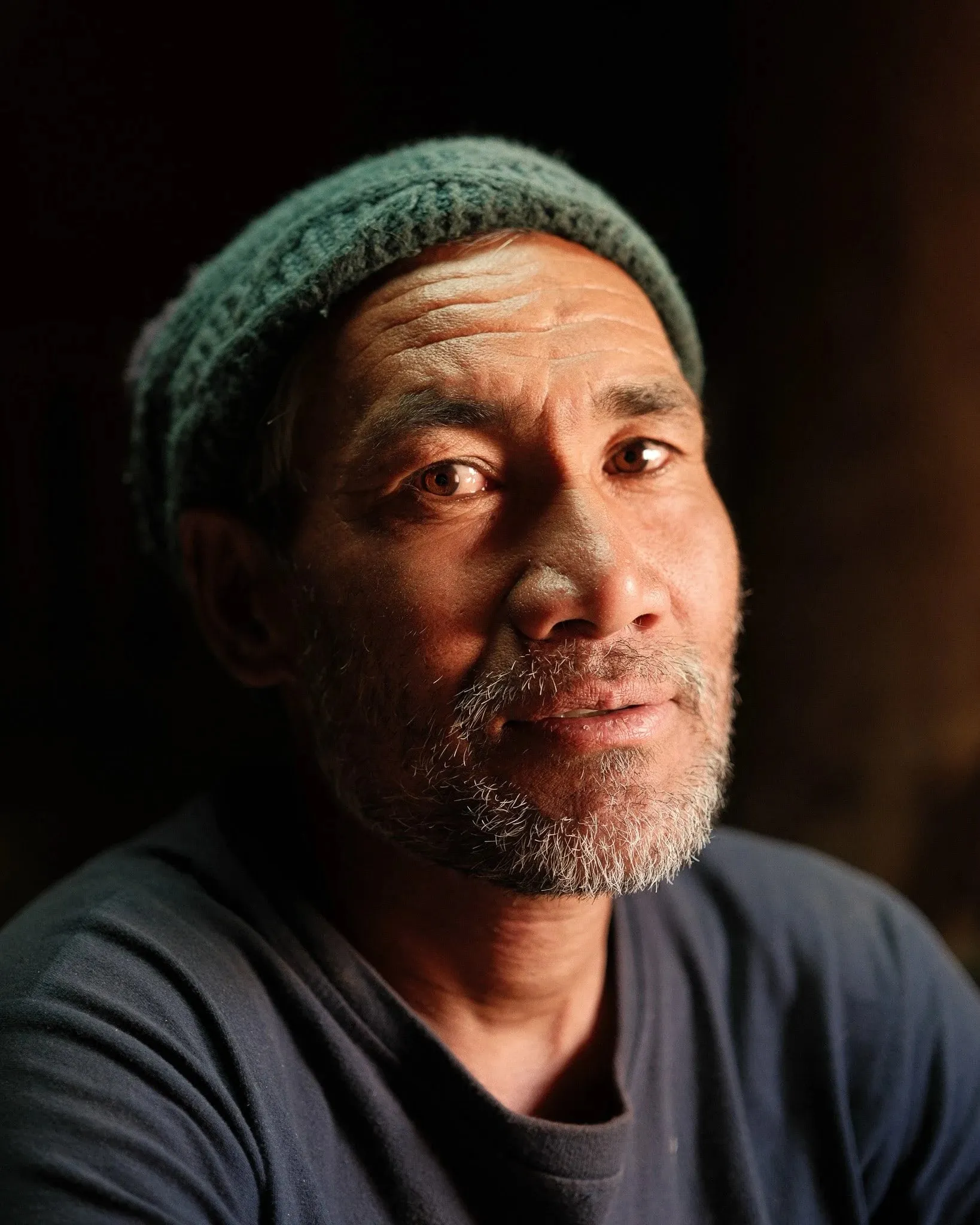 Portrait of a man in a green knitted hat in soft window light