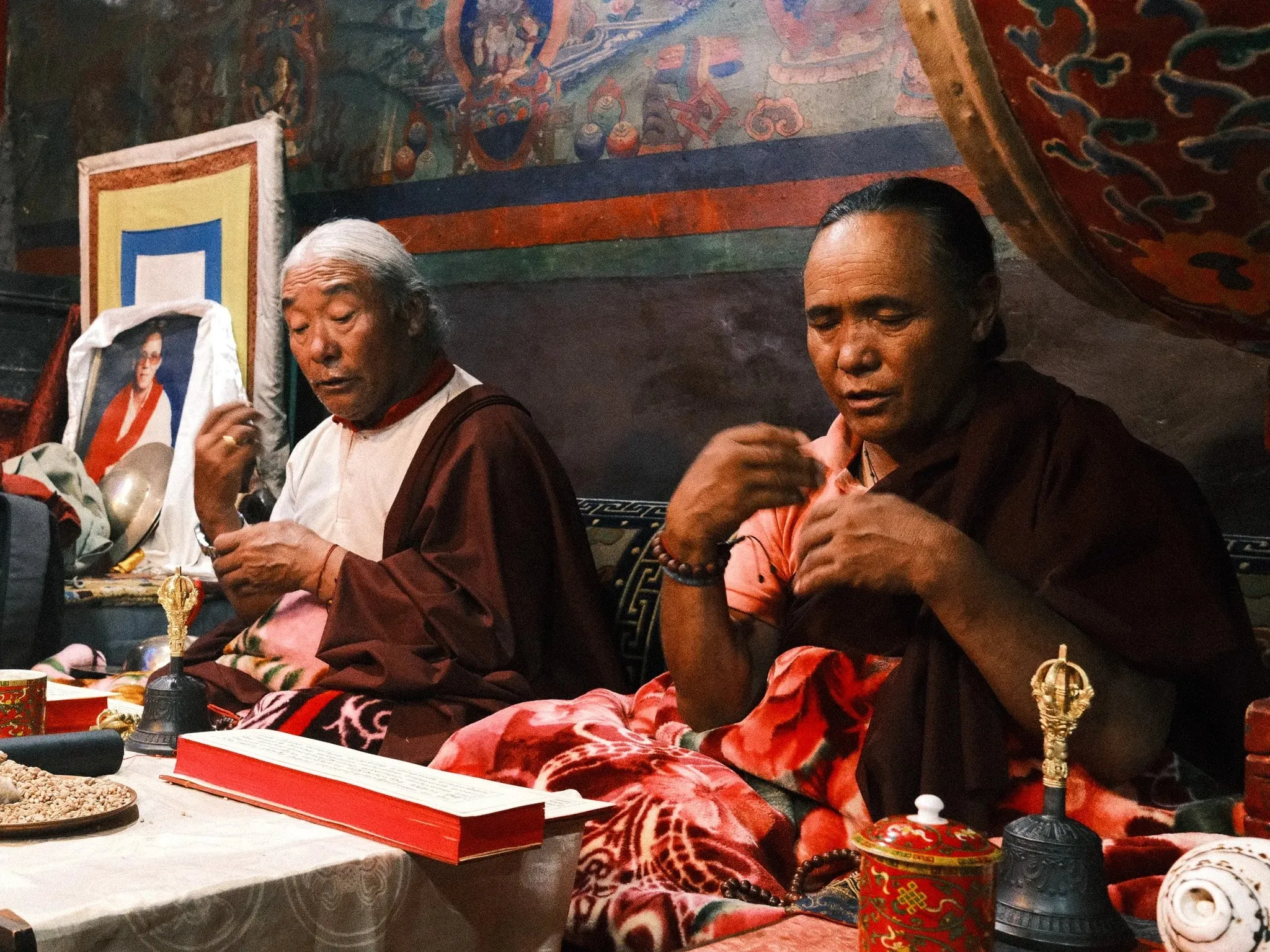 Colour photo of two monks during a puja ceremony in Upper Mustang, Nepal.