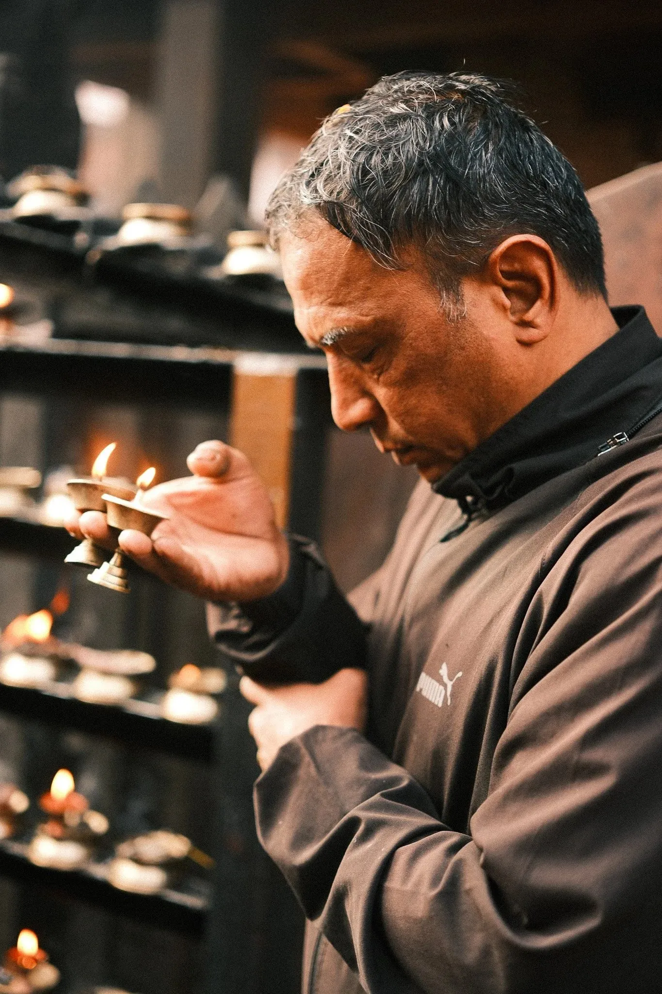 A man lighting a butter lamp at a shrine in Kathmandu Durbar Square
