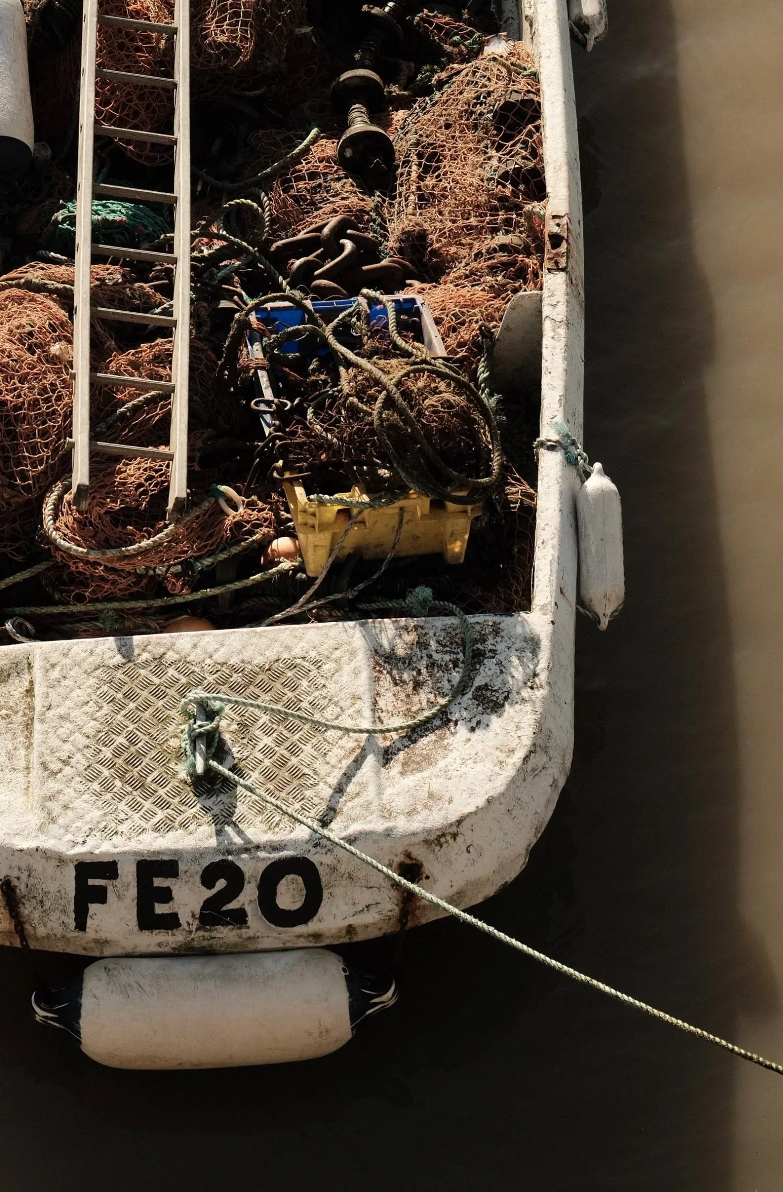 A fishing boat marked FE20 seen from above, its deck full of nets and gear