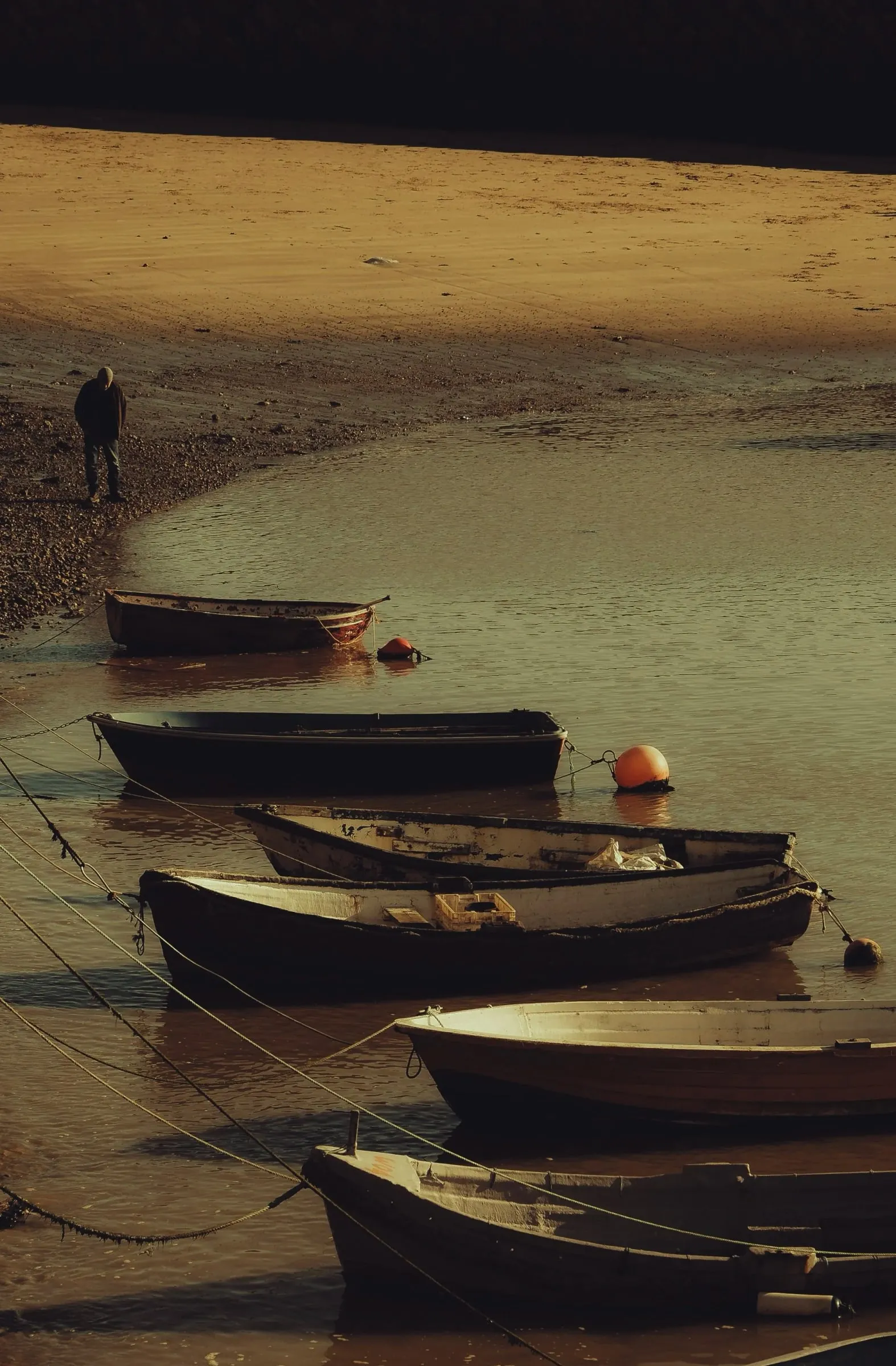 Rowing boats moored on the wet sand at low tide in Folkestone harbour