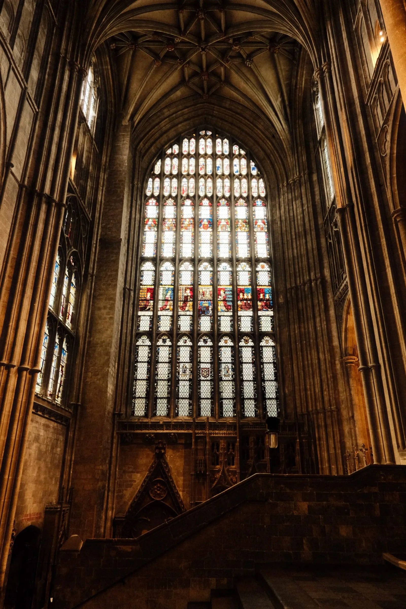 The great stained glass window at the end of the nave, framed by tall stone columns
