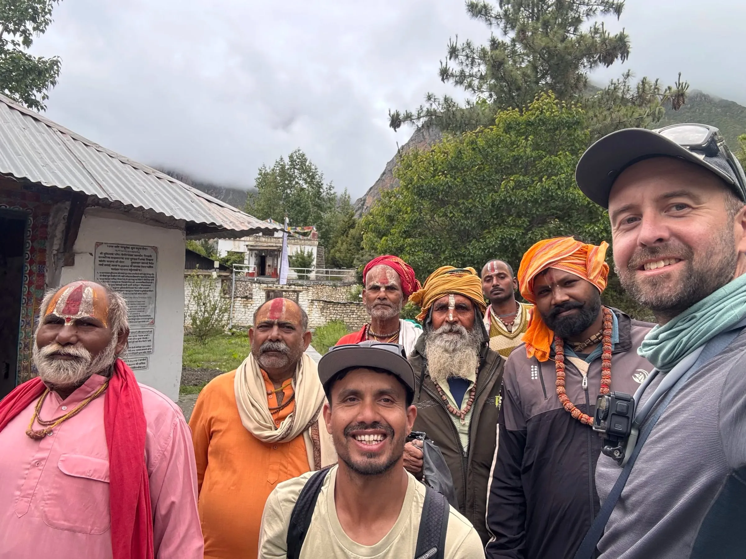 A group selfie with a guide, a trekker and several sadhus
