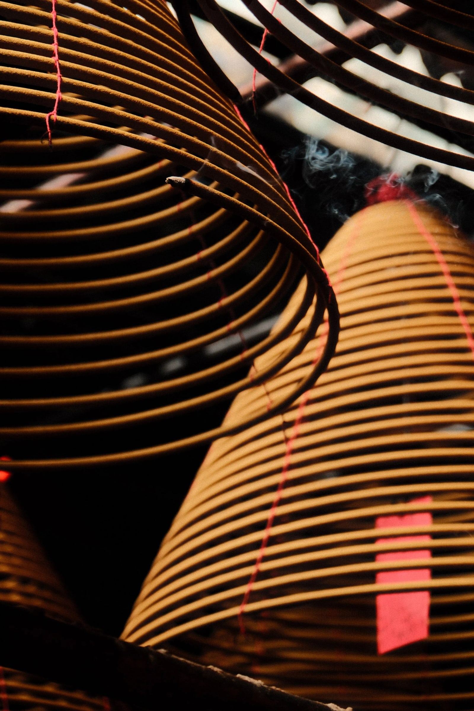 Close view of large incense coils hanging from a temple ceiling