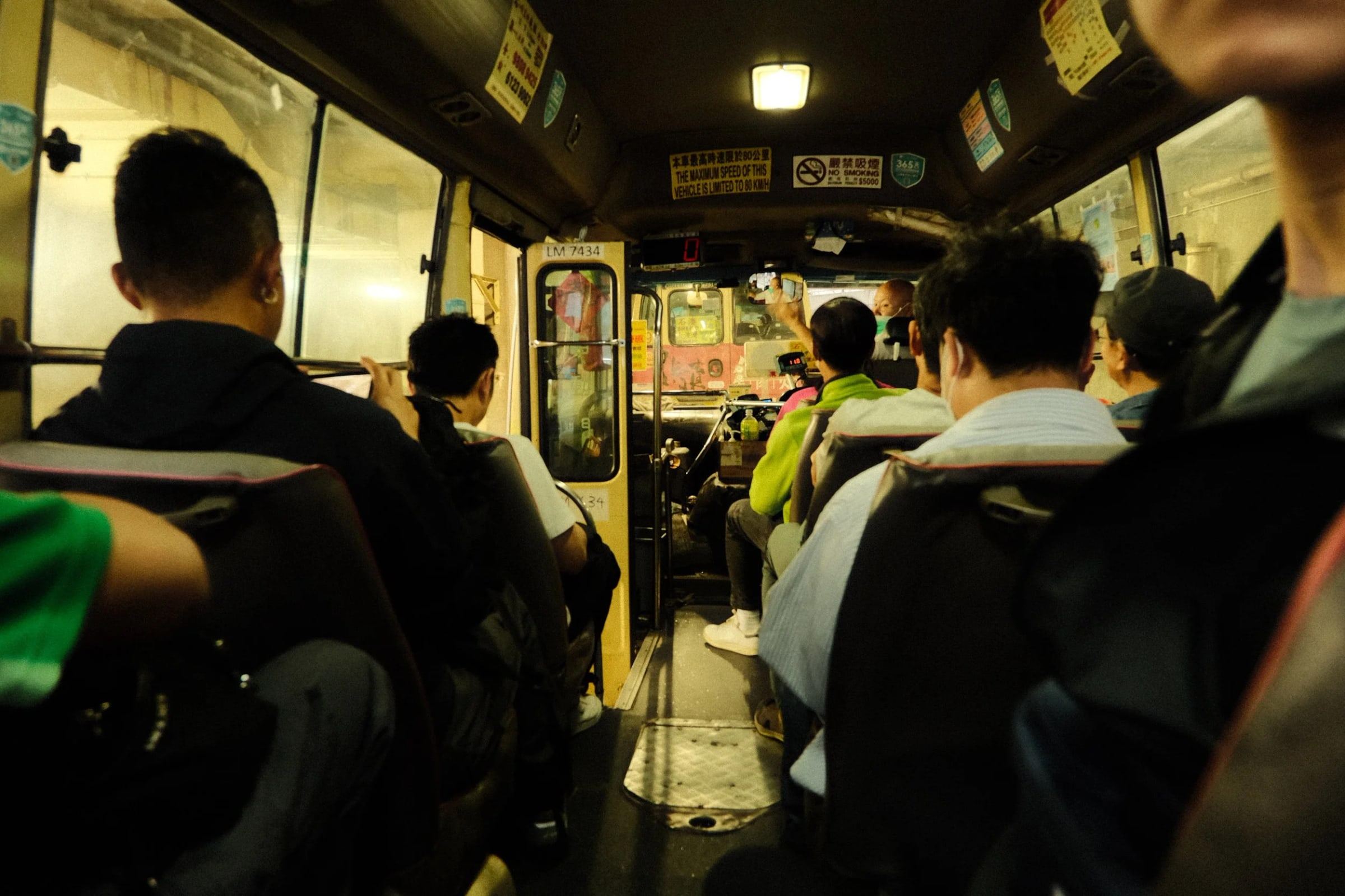 Passengers seated on a minibus, seen from the back row