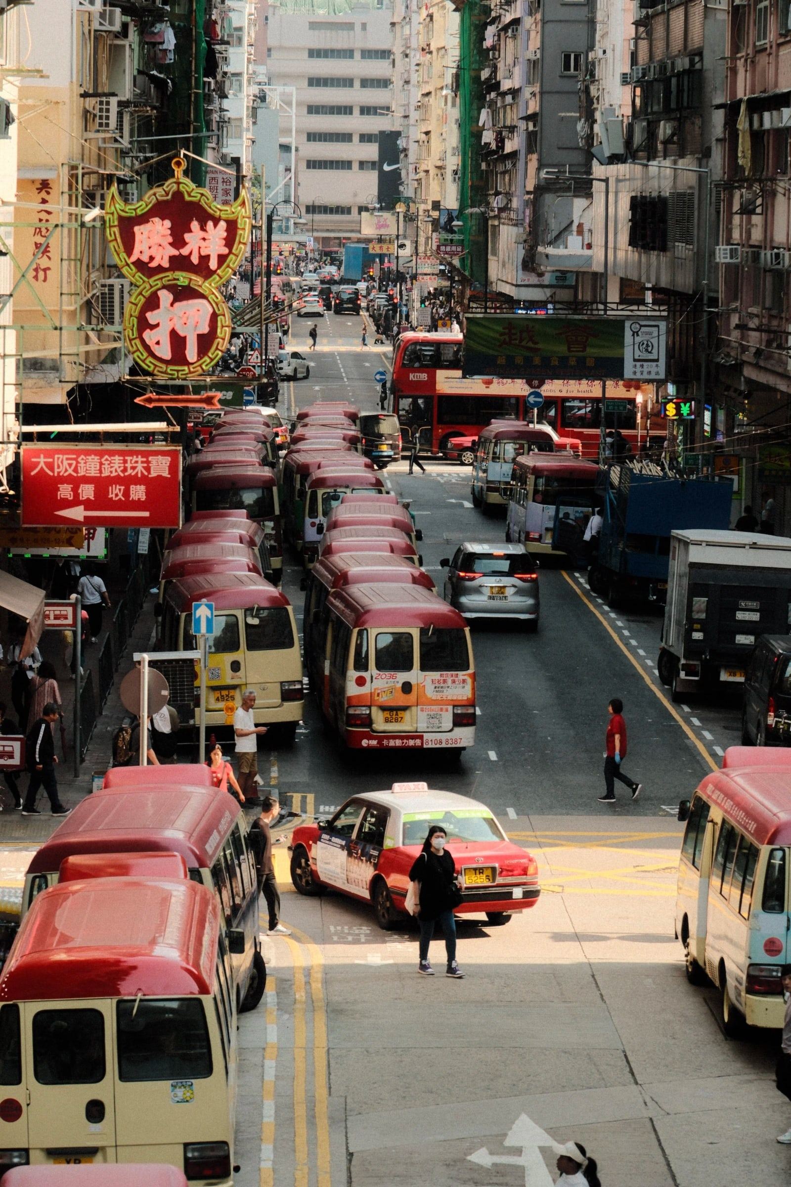 Red and cream minibuses queued along a busy street, seen from above