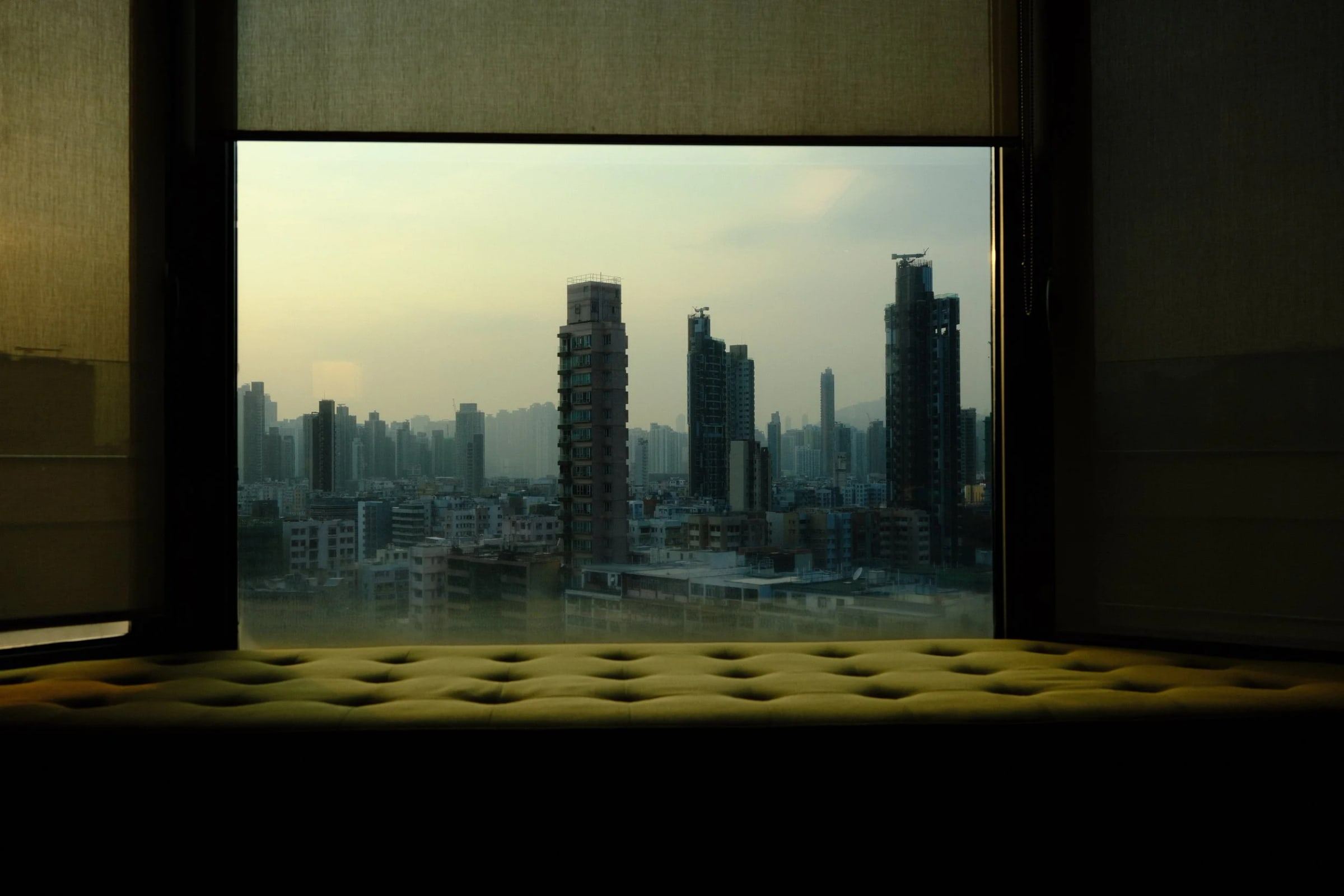 City skyline seen through a window from a dark interior