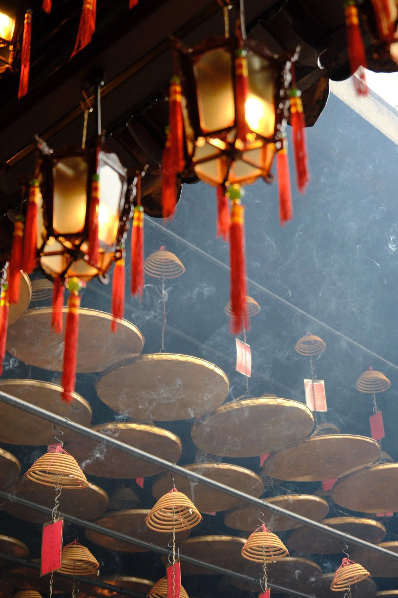 Red lanterns and incense coils hanging in a temple