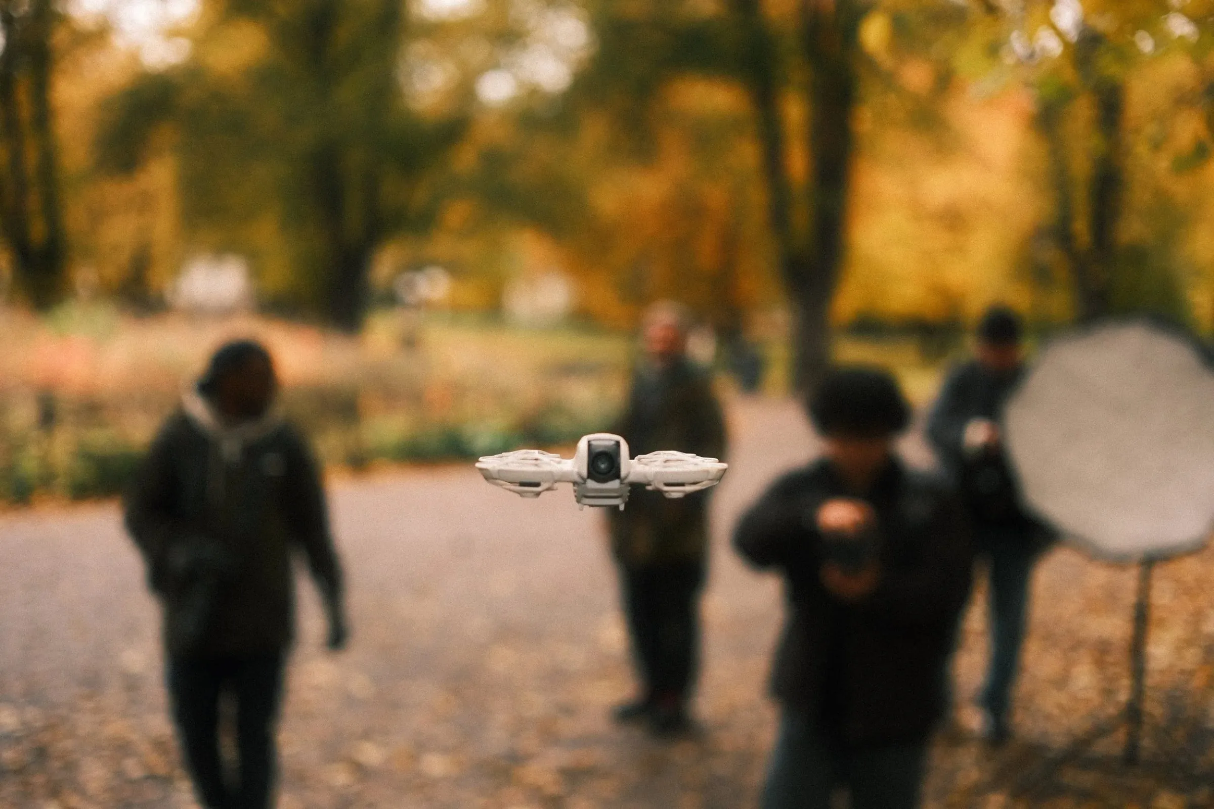 A drone hovering in front of blurred photographers in Humlegården