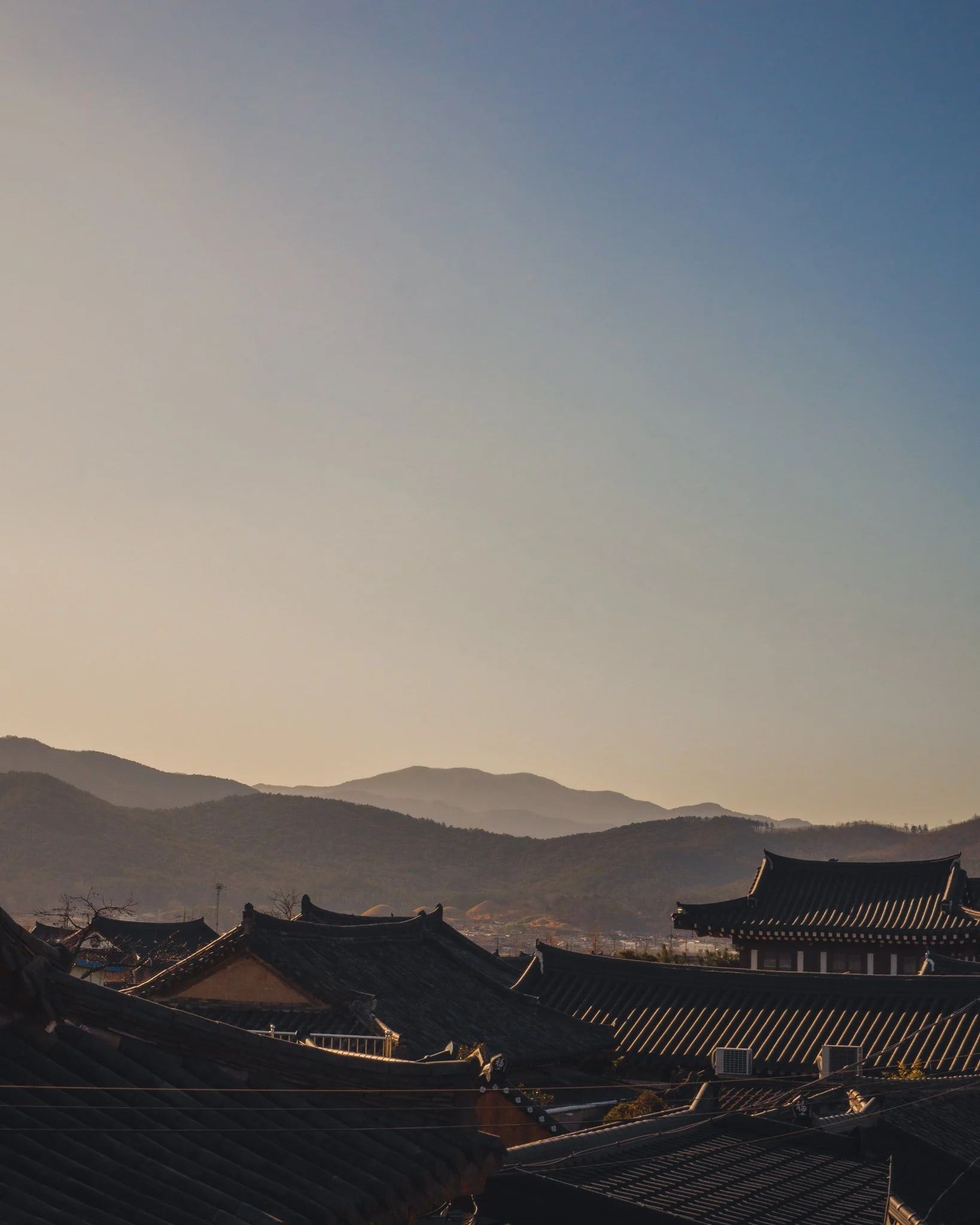 Traditional rooftops and hills at dusk