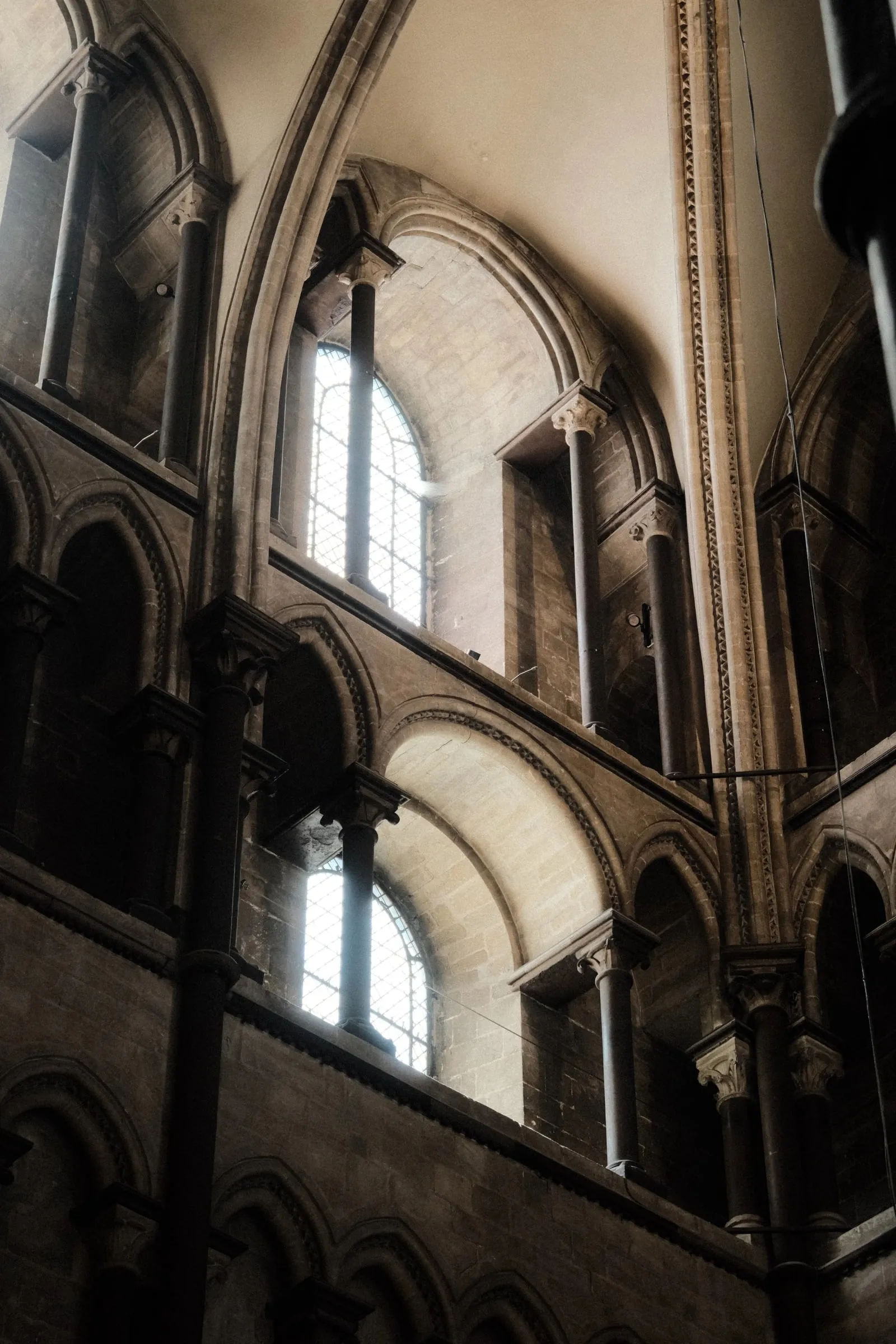 Rounded arches and windows along the upper walls of the cathedral, lit by soft daylight
