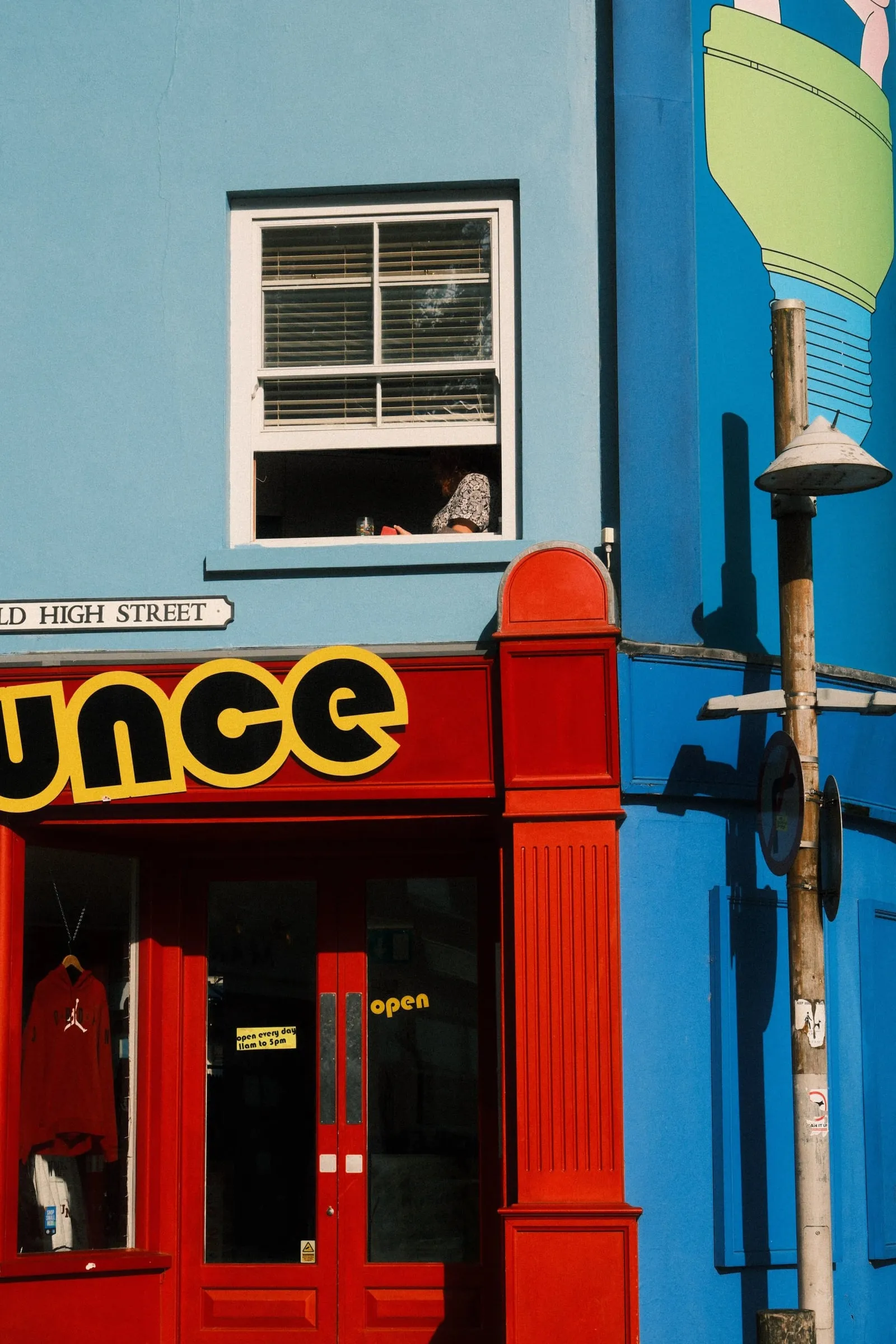 A bright blue building with a red shopfront on the Old High Street