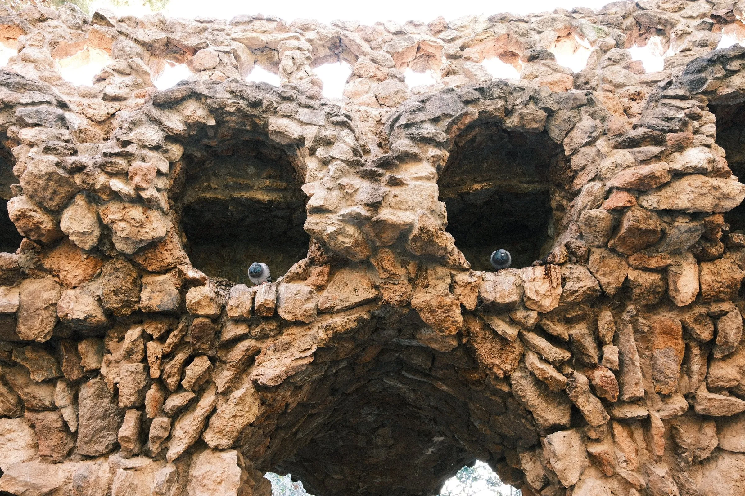 Rough stone arches of a viaduct in Park Güell