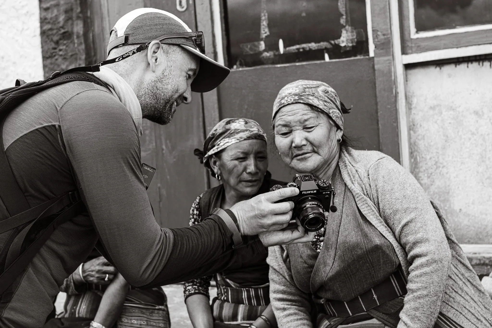 Photographer showing two older women their portraits on a camera in Lo Manthang, Upper Mustang, Nepal.