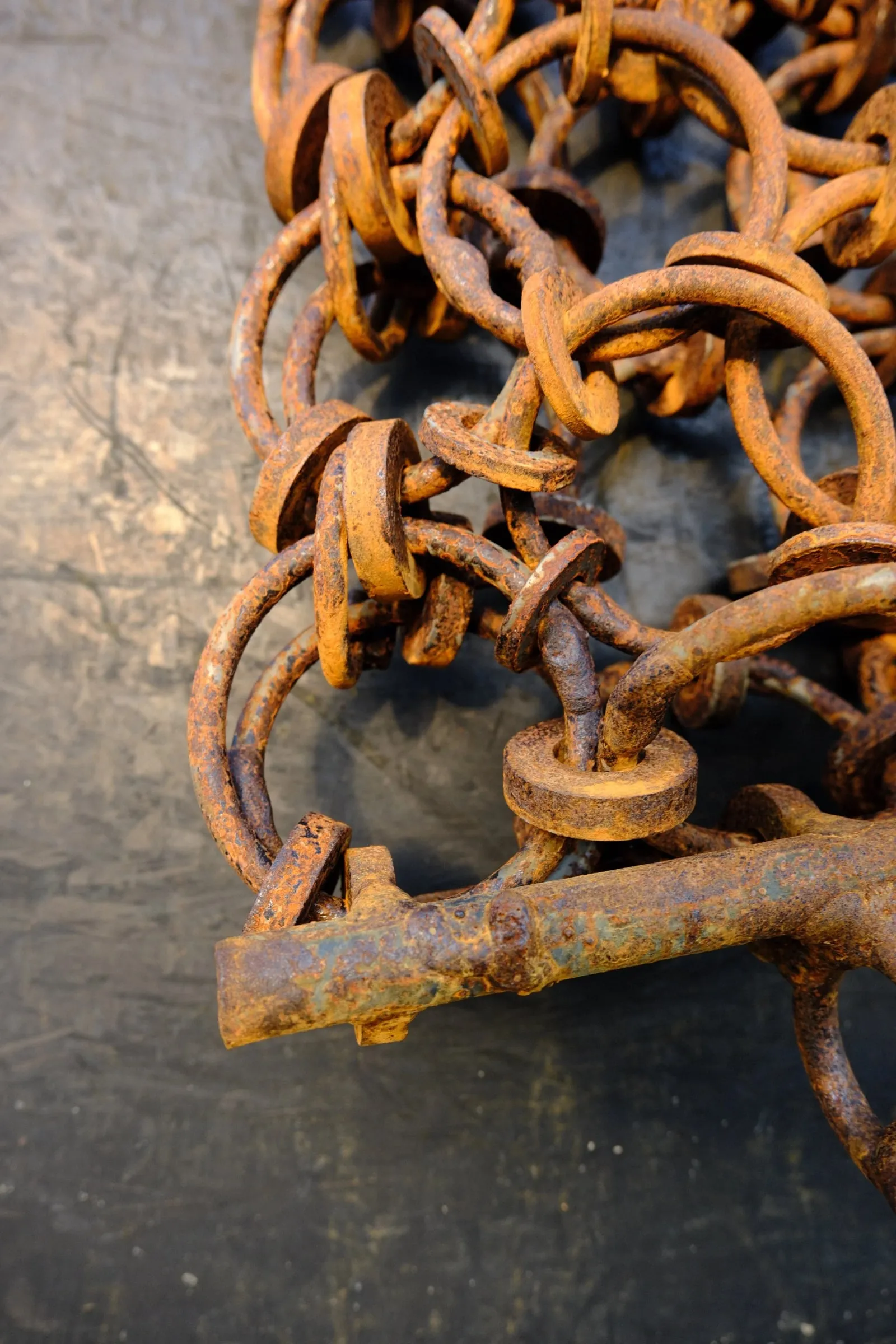 A tangle of rusty chain lying on metal