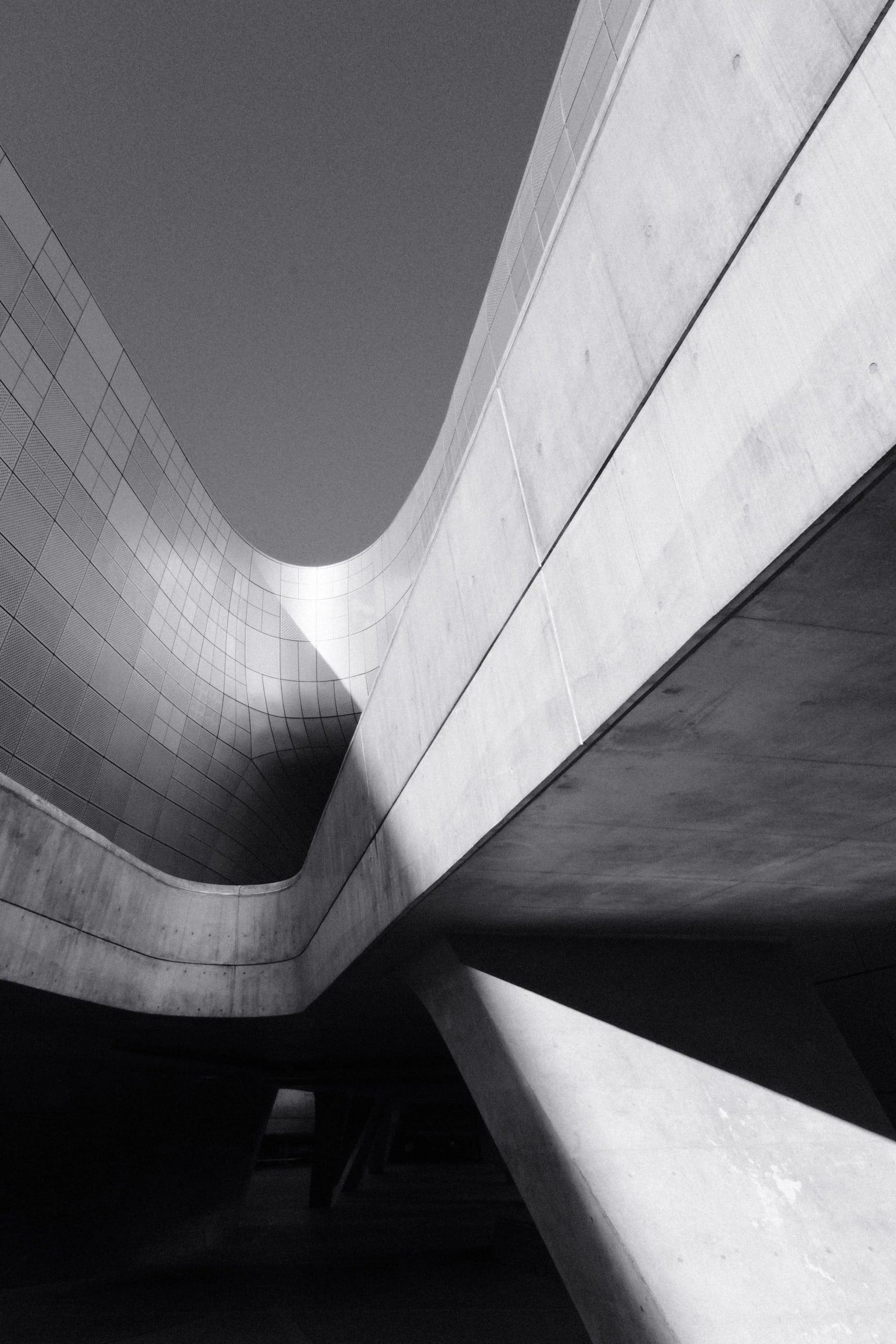 Curving concrete forms rising against a dark sky