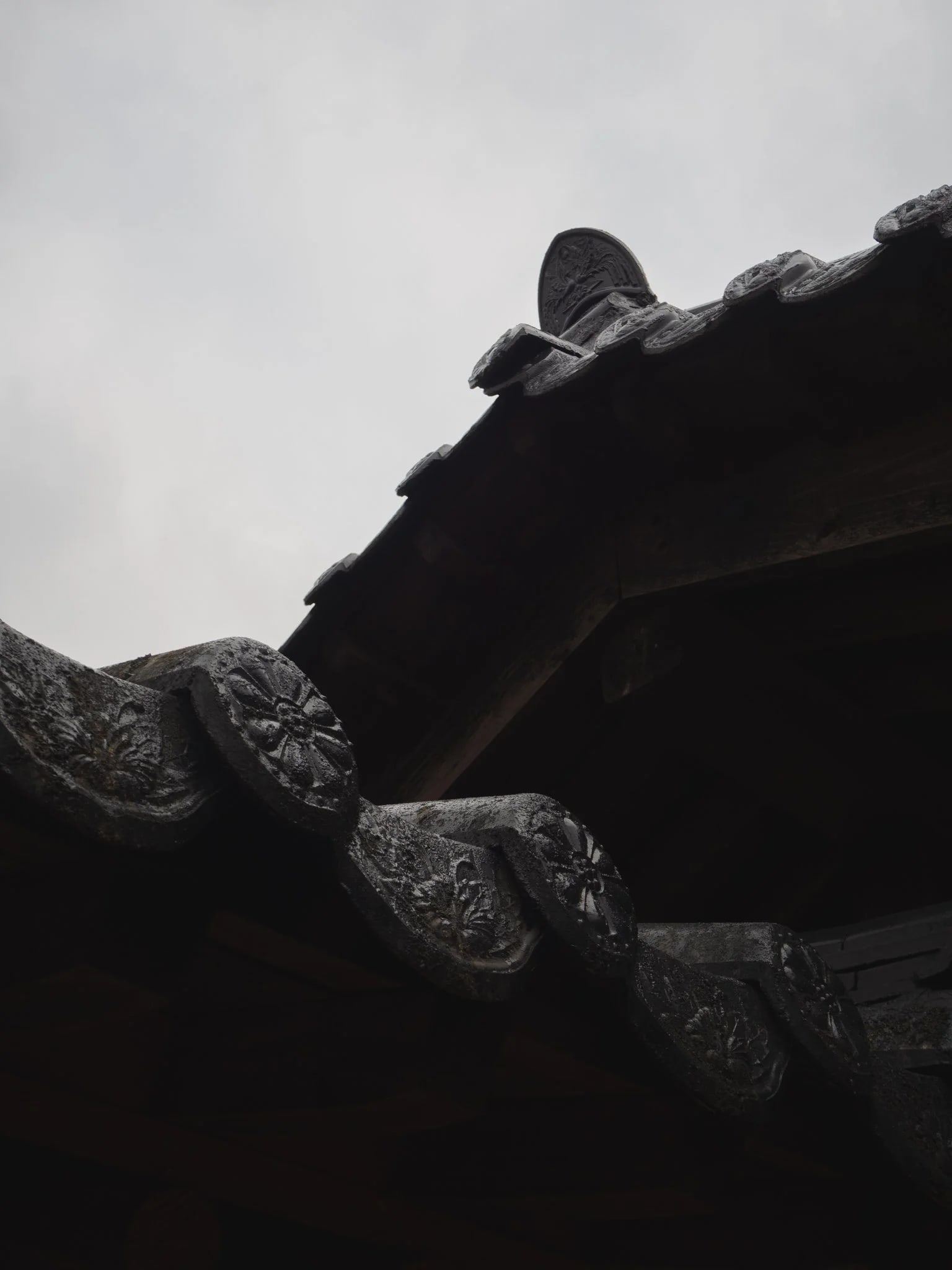 Edge of a traditional tiled roof in deep shadow