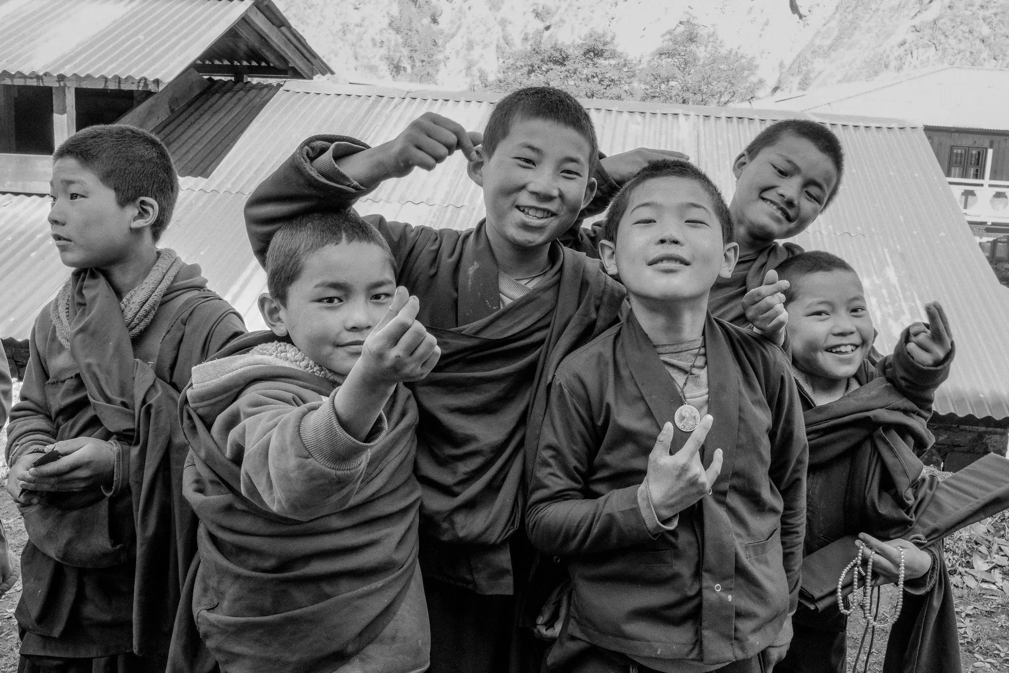 Black and white photo of a group of smiling young monks posing for the camera