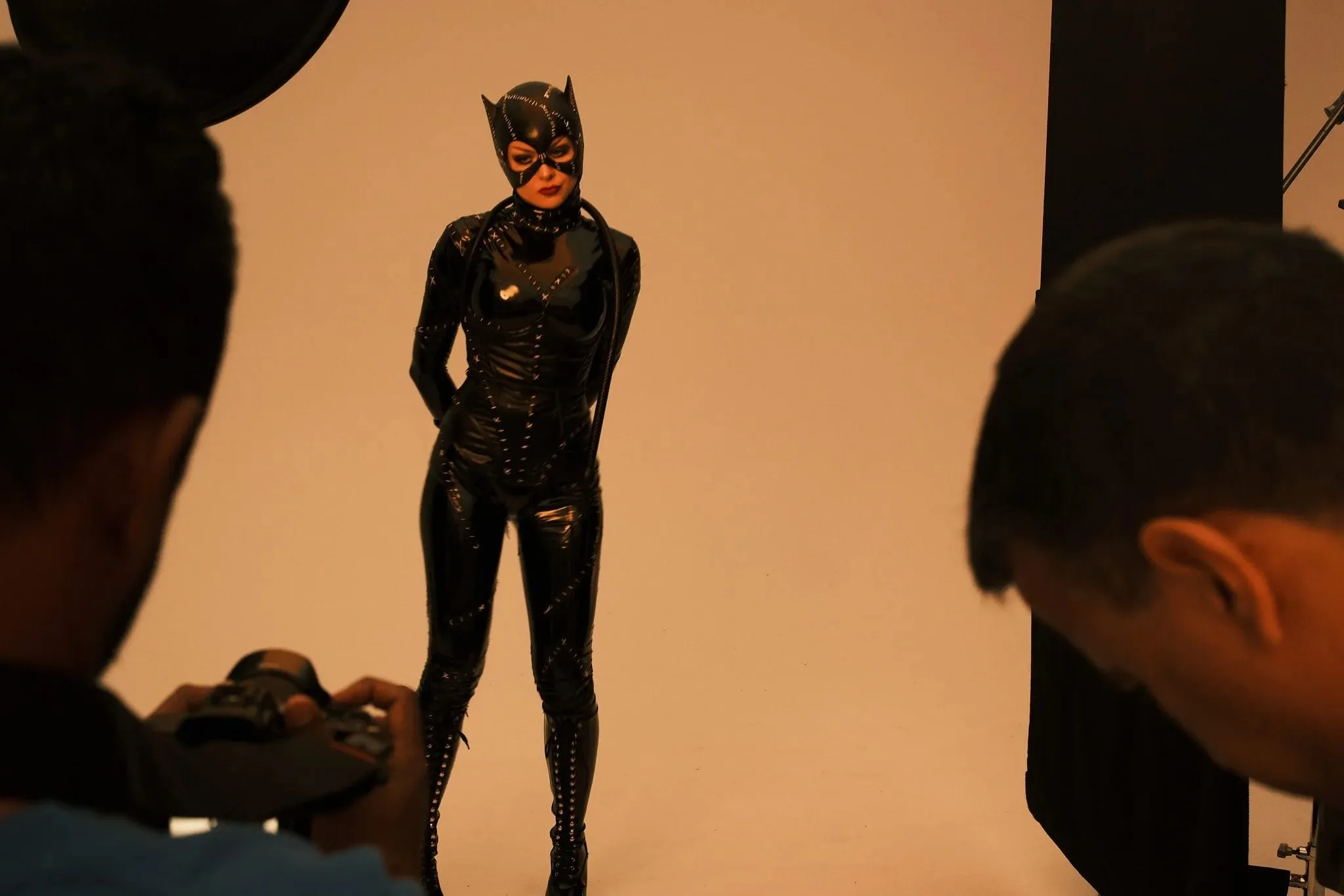A model in a Catwoman costume posing in the studio while photographers shoot