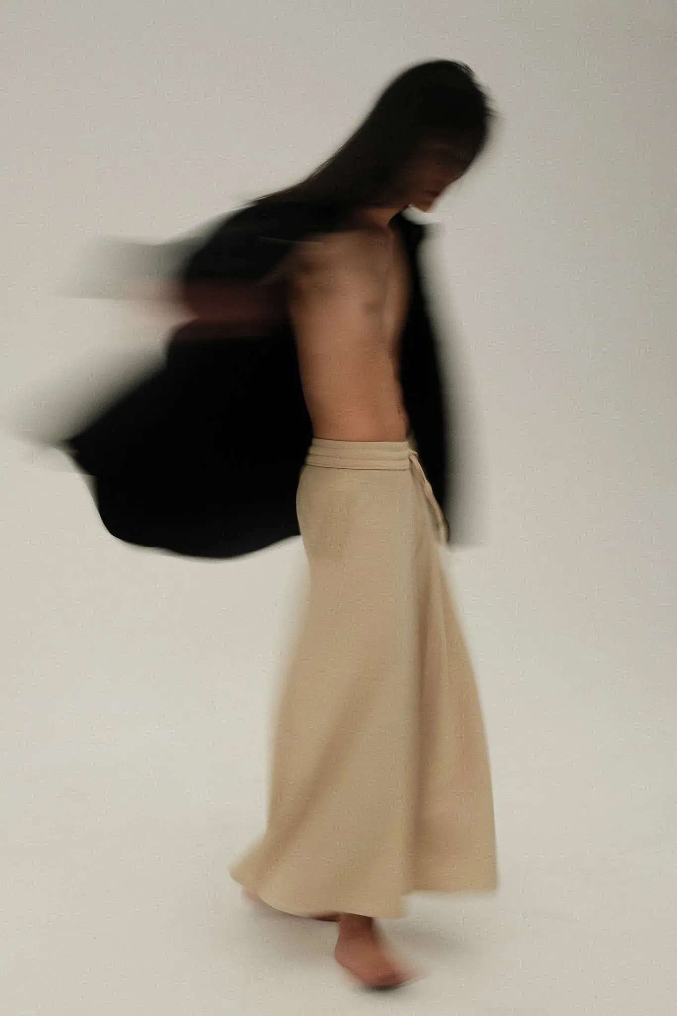 A model spinning, blurred by movement, against a pale backdrop