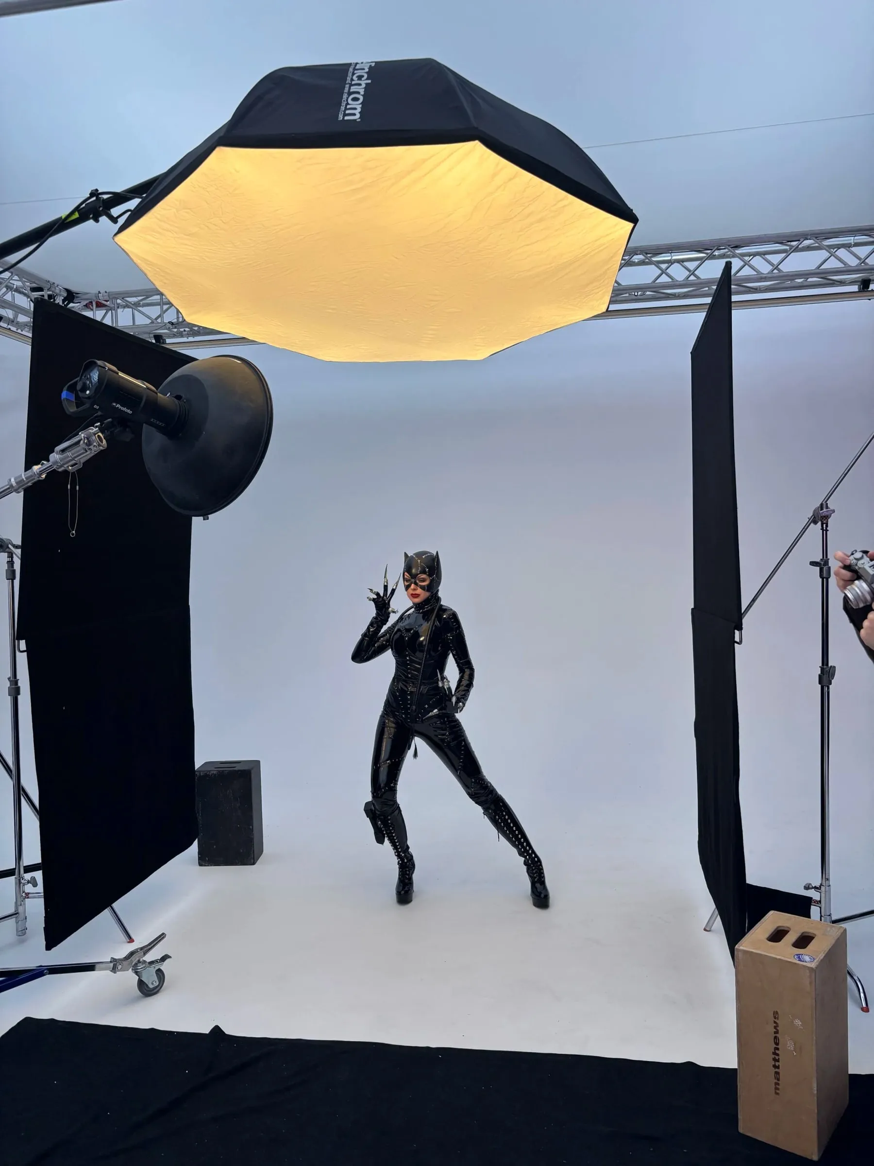 A model in a Catwoman costume posing under a large octagonal softbox