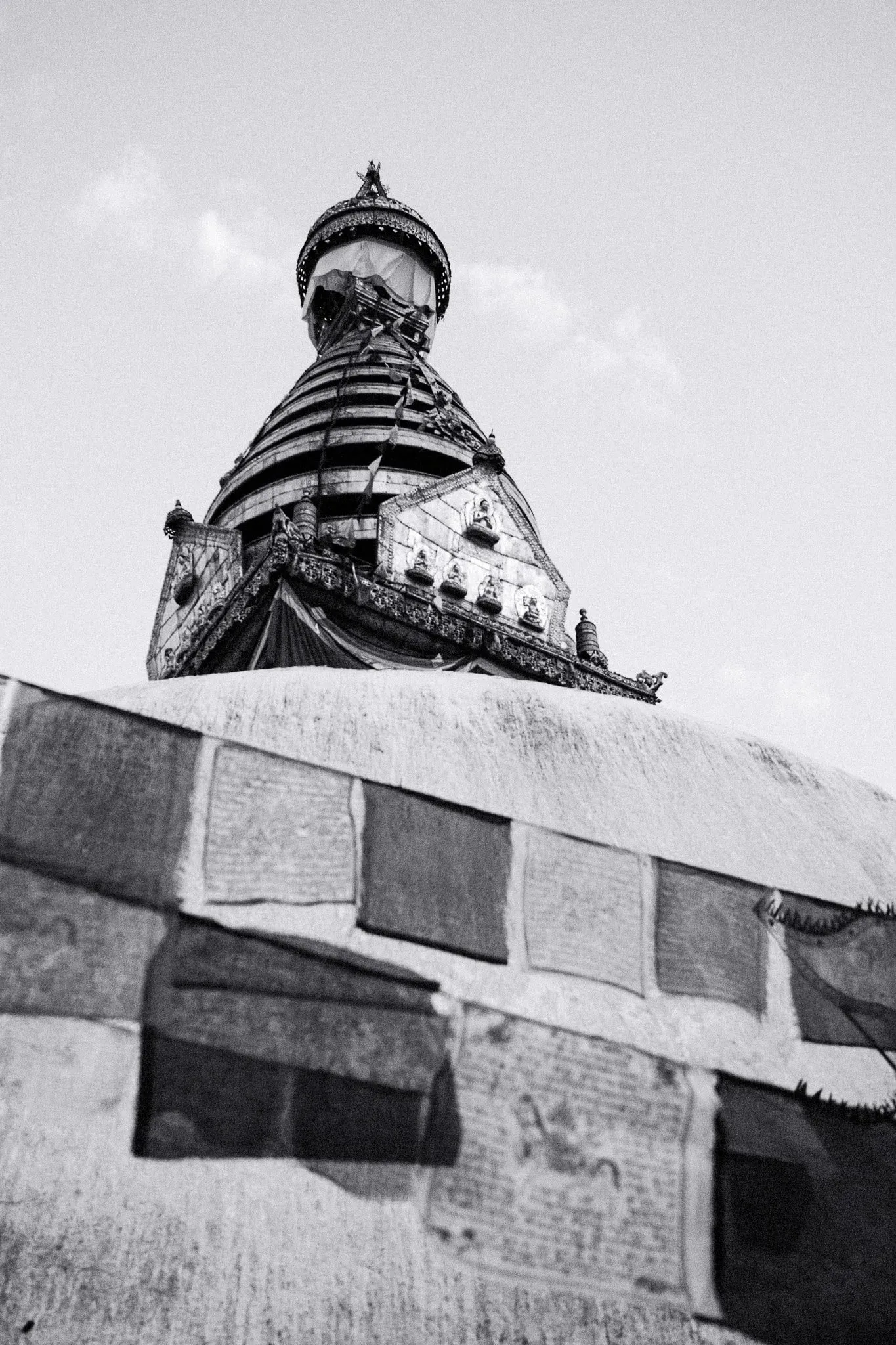 Black and white photo of the Swayambhu stupa spire above its whitewashed dome
