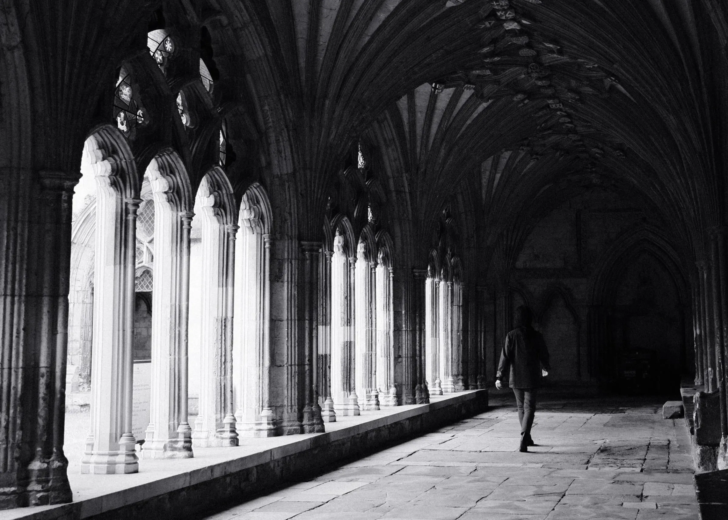 A woman walking through the cloister at Canterbury Cathedral